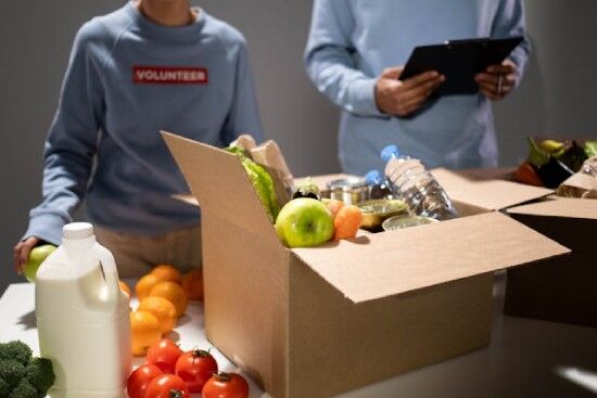 Volunteers fill boxes with produce, water, and other staples.