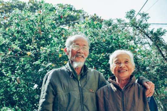 An elderly couple standing outside enjoying nature