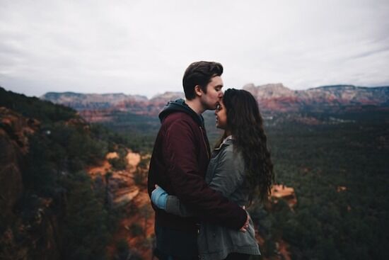 Man and woman embracing on a mountaintop A man and woman embracing on top of a mountain