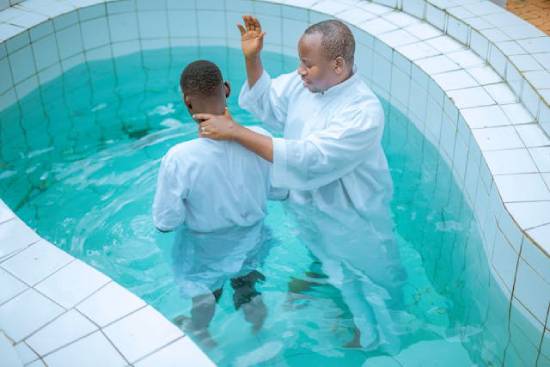 A pastor prepares to baptize a young man A pastor prepares to baptize a young man in a pool, demonstrating the biblical concept of baptism by immersion.