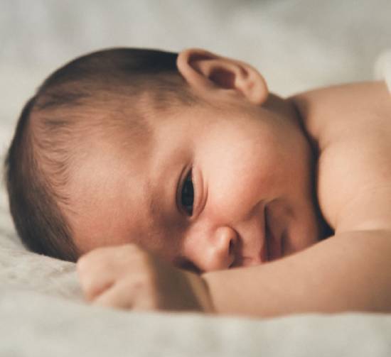 A baby lying on a soft blanket