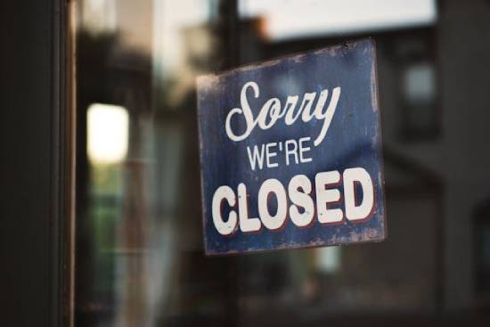 A sign on the door of a business that reads "Sorry we're closed" A business sign on a door that reads,