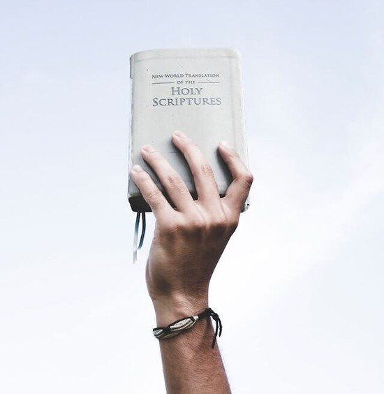 Hand Holding Bible Up A hand raising the Holy Scriptures, which Ellen White believed should be the foundation for true education