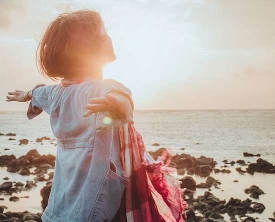 Woman Saved and Free A woman standing on a beach, arms outstretched, symbolizing our free will