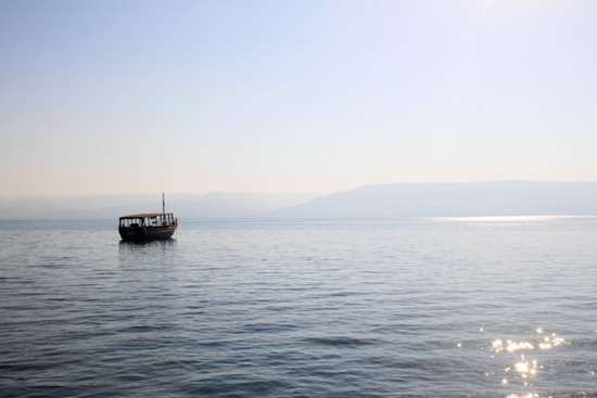 Sea of galilee near Jesus' ministry A boat floats away on the shimmering waters of the Sea of Galilee.