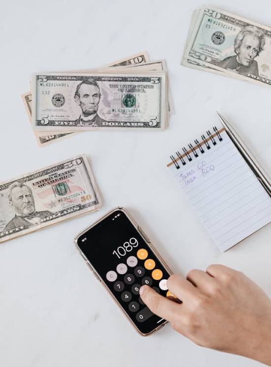 Money, Calculator, and Debt List on a Table We see the image of a cash next to cash, a calculator, and a debt list. And it reminds us that while debt isn't a sin, it can make our lives difficult.